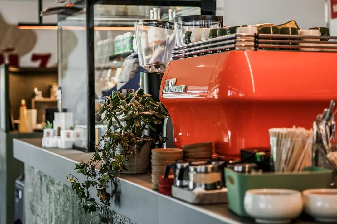 Il bancone caffè dello Smúz con la macchina espresso arancione Il bancone caffè dello Smúz con la macchina espresso arancione
