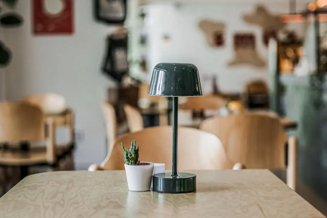 Un tavolo accogliente con lampada all’interno dello Smúz Café Un tavolo accogliente con lampada all’interno dello Smúz Café