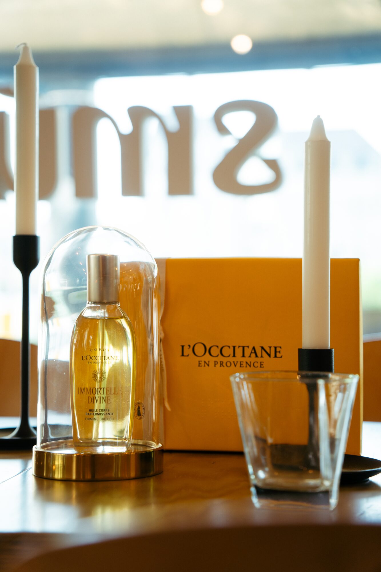 L'Occitane Immortelle Divine perfume at Smúz Café Budapest — product display with candles